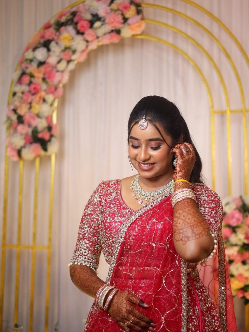 Bride in a red embellished saree with soft rose makeup